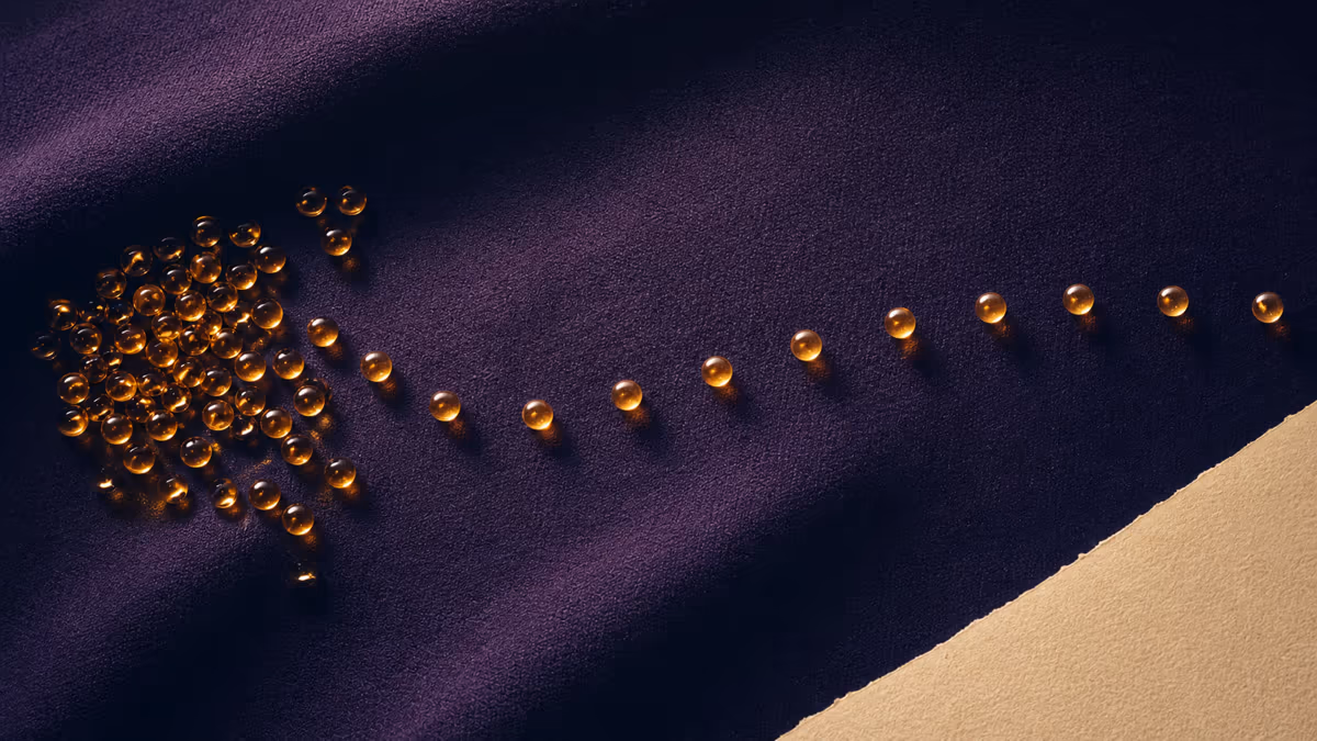 Amber glass beads moving from a crowded cluster into an evenly paced rhythm